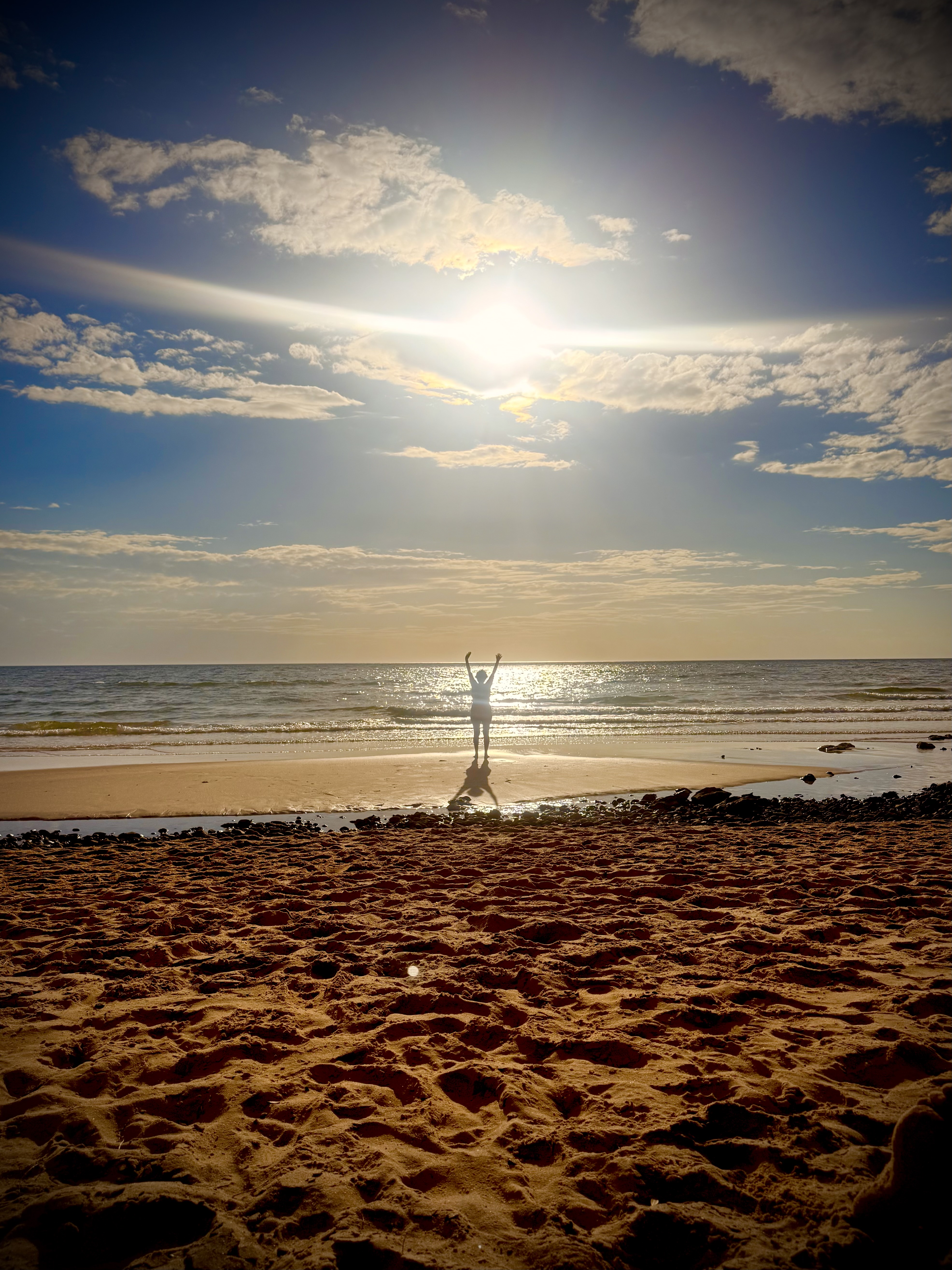 Jacqui standing on a beach at sunset
